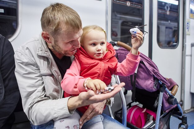 Mała dziewczynka bawi się zabawkowym helikopterem podczas podróży do wagonu metra