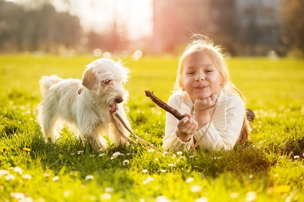 Mała dziewczynka bawi się ze swoim szczeniakiem w parku