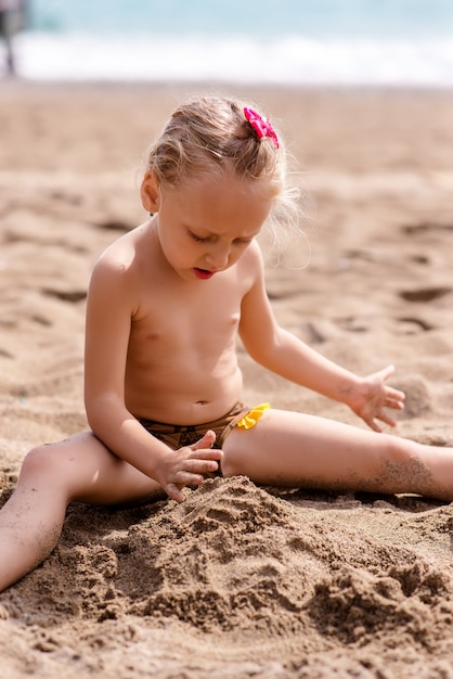 Mała dziewczynka bawić się w piasku.