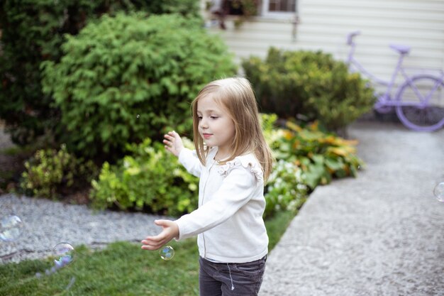 Mała dziewczynka bawić się z bąblami w naturze