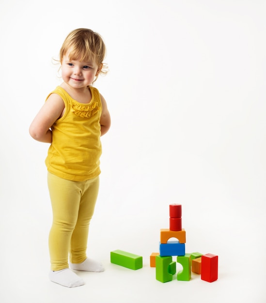 Mała dziewczynka bawić się z kolorowymi zabawkarskimi blokami