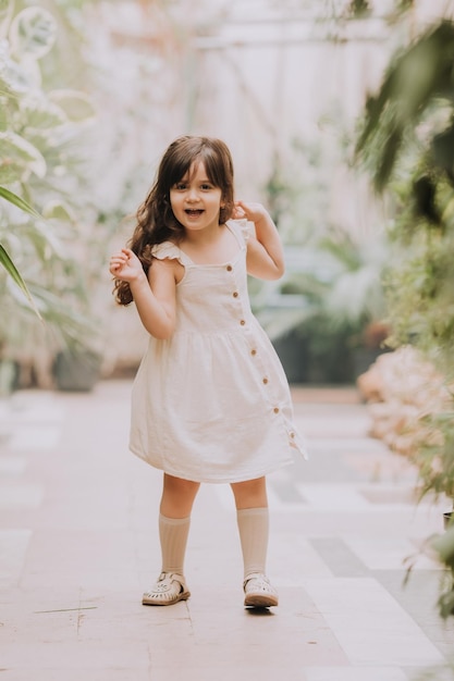 Mała dziewczynka chodzi w ogrodzie botanicznym szczęśliwe dziecko i palmy
