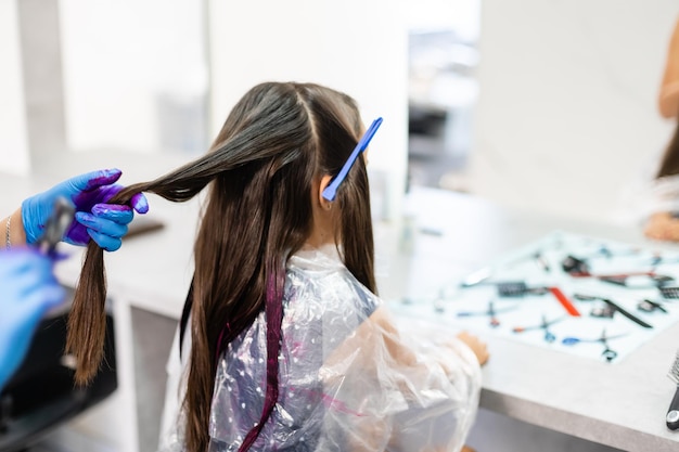 mała dziewczynka farbuje włosy na fioletowo w salonie fryzjerskim