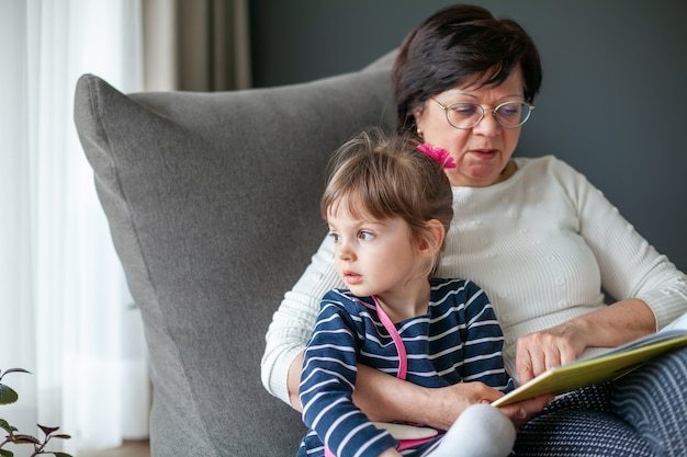 Mała dziewczynka i jej babcia spędzają razem czas czytając książkę, siedząc na krześle worek fasoli. Babcia opowiada wnuczce historie.