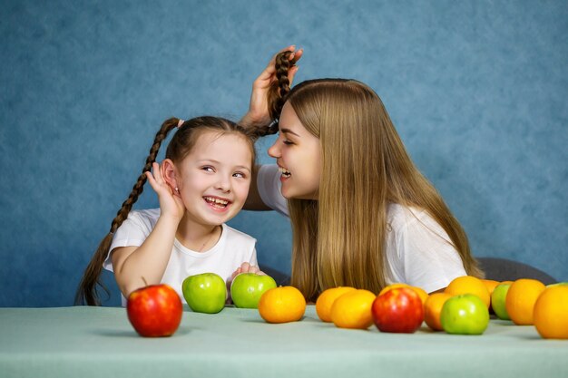 Mała Dziewczynka I Mama Bawią Się Owocami I Wygłupiają. Noszą T-shirty