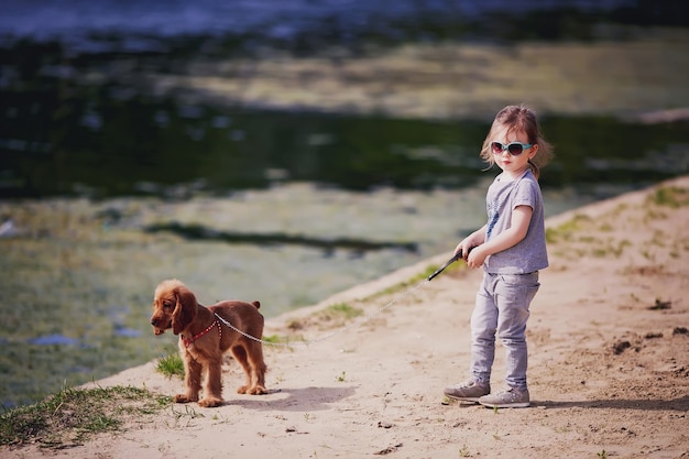 Mała dziewczynka i pies na plaży w słoneczny letni dzień Dziecko ze szczeniakiem na zewnątrz