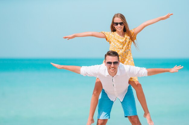 Mała dziewczynka i szczęśliwy tata ma zabawę podczas wakacje na plaży