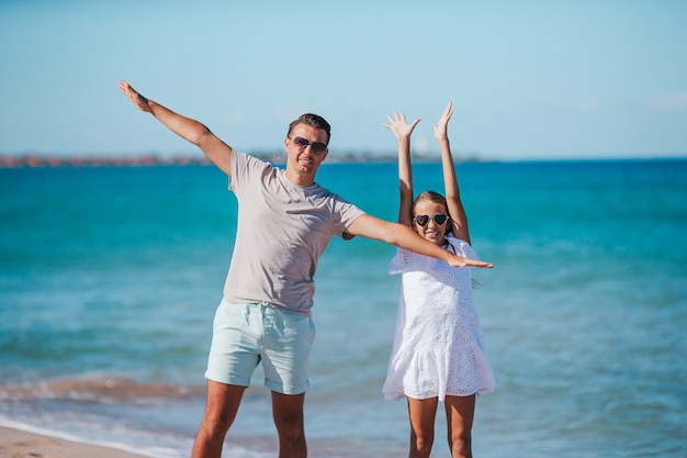 Mała dziewczynka i szczęśliwy tata, zabawy podczas wakacji na plaży
