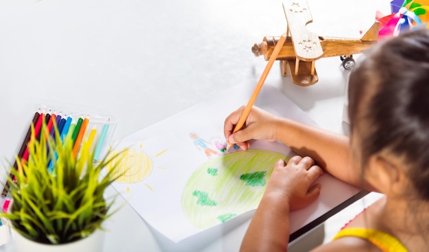 Mała dziewczynka kolorowy rysunek rodziny stojącej trzymaj się za ręce na planecie Ziemia na papierze