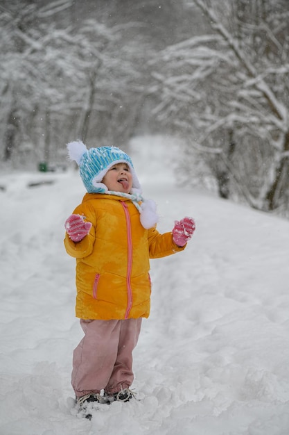 Mała dziewczynka łapie płatki śniegu na język