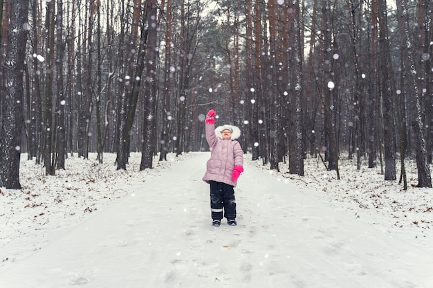 Mała Dziewczynka łapie Płatki śniegu W śniegu W Winter Park