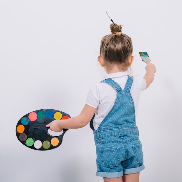 Zdjęcie mała dziewczynka maluje ścianę z muśnięciem