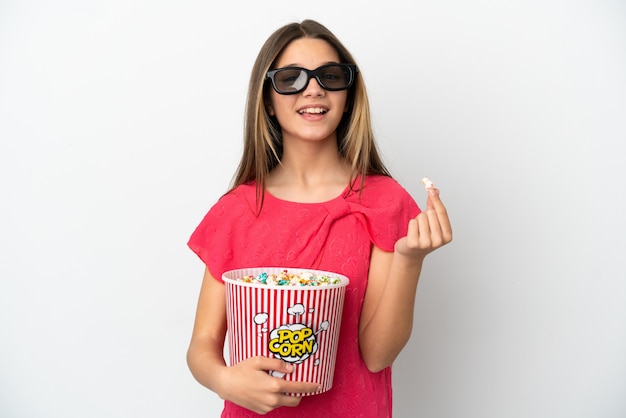 Mała dziewczynka na białym tle w okularach 3d i trzymająca duże wiadro popcornów