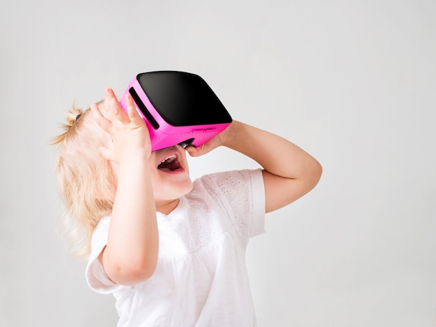 Mała dziewczynka patrząc w okularach wirtualnej rzeczywistości w domu. Skandynawskie wnętrze