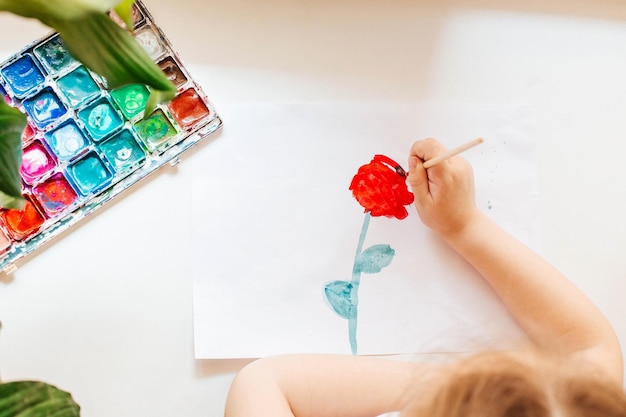Zdjęcie mała dziewczynka rysująca kartkę z życzeniami na dzień matki koncepcja dnia matki kartka urodzinowa z okazji urodzin