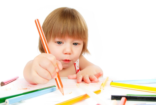Mała dziewczynka rysuje ołówkiem na białym tle