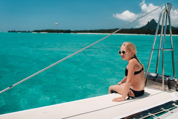 Mała Dziewczynka Siedzi Na Katamaranie Na Oceanie Indyjskim. Portret Dziewczynki Na łodzi Na Rafie Koralowej Na Wyspie Mauritius.