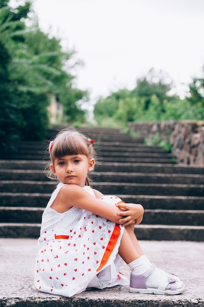Mała dziewczynka siedzi na schodach