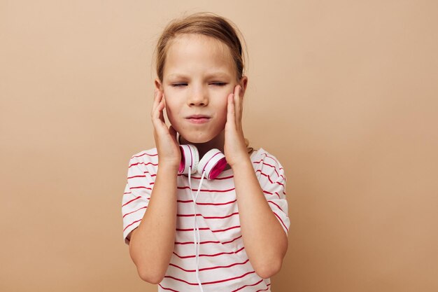 Zdjęcie mała dziewczynka słuchawki rozrywki emocje na białym tle