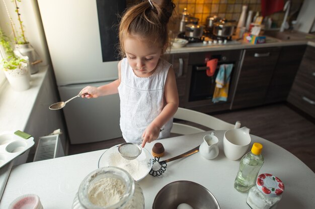 mała dziewczynka sprawia, że ​​ciasteczka w kuchni