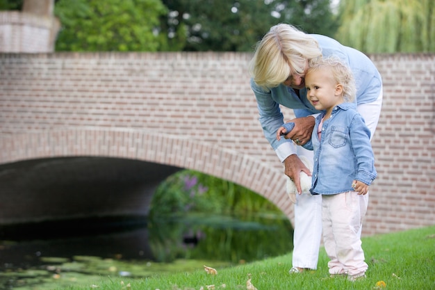 Mała dziewczynka stoi outdoors z babcią w parku