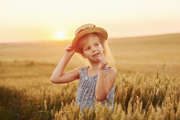 Mała dziewczynka stojąca na polu rolnym wieczorem Poczęcie letniego czasu wolnego