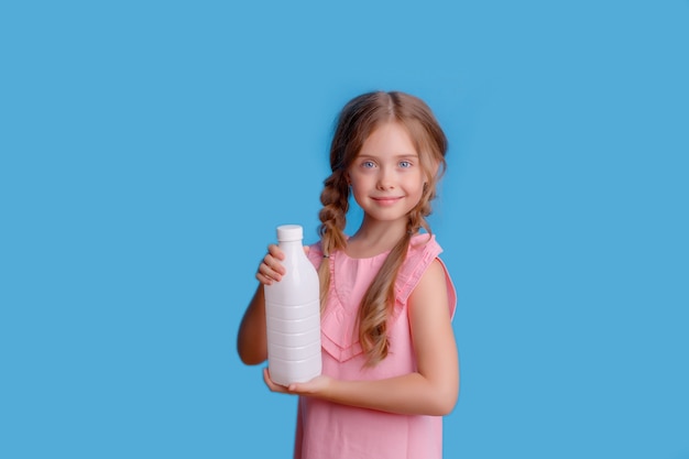 Mała dziewczynka trzyma butelkę mleka