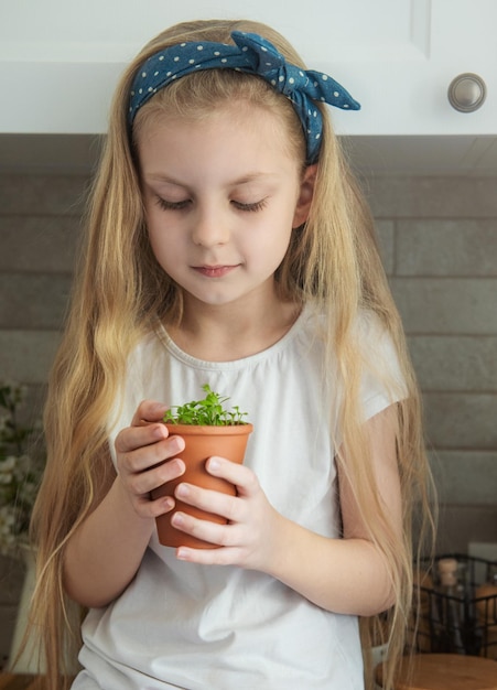 Mała dziewczynka trzyma garnek sadzonek