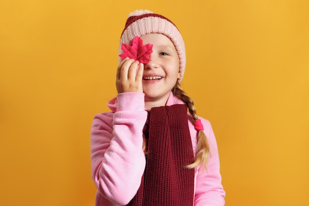 Zdjęcie mała dziewczynka trzyma liść klonu.