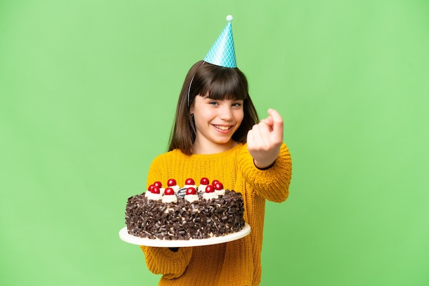 Mała dziewczynka trzymająca tort urodzinowy na odizolowanym tle klucza chrominancji, wykonująca nadchodzący gest