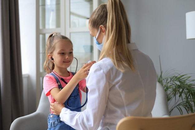 Mała dziewczynka u lekarza na badanie Dziecko osłuchuje bicie serca lekarza