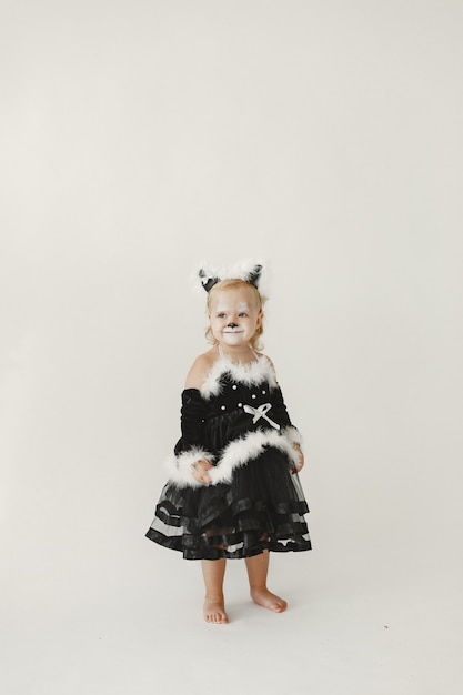 Mała dziewczynka ubrana w czarną sukienkę jak kot