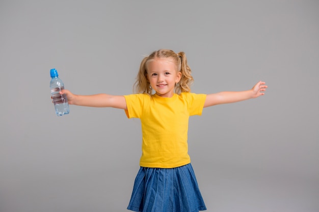 Mała Dziewczynka Uśmiecha Się Trzymając Butelkę Wody