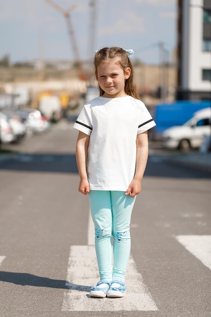 Mała dziewczynka w białej przestrzeni tshirt na logo lub projekt makiety do druku