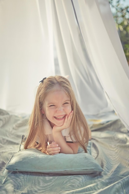 Mała dziewczynka w białym szyfonowym namiocie