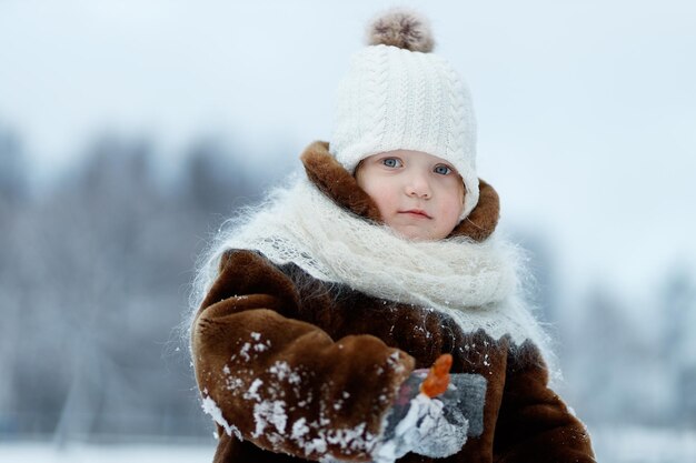 Mała dziewczynka w futrze na zimowym tle