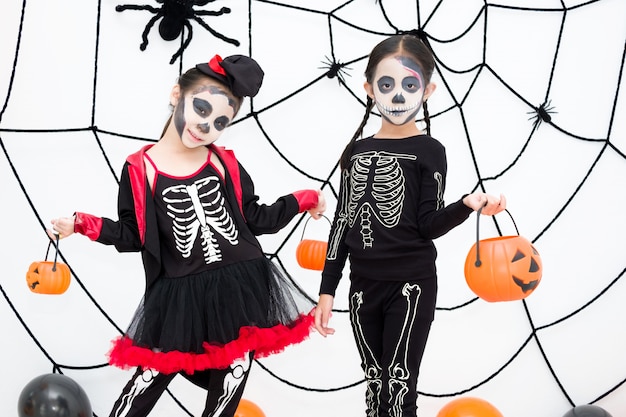 Zdjęcie mała dziewczynka w halloweenowym karnawałowym kostiumu trzyma lampion jacka