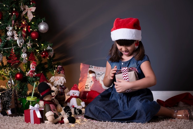 Mała Dziewczynka W Kapeluszu świętego Mikołaja W świątecznych Dekoracjach
