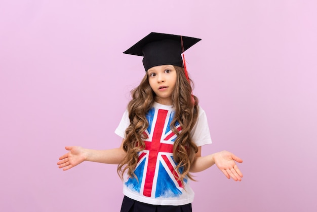 Mała dziewczynka w mistrzowskiej czapce i koszulce z flagą Wielkiej Brytanii rozkłada ręce ze zdziwienia Ukończenie liceum