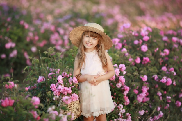 Mała dziewczynka w ogrodzie herbacianej róży