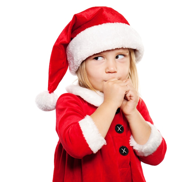 Mała dziewczynka w Santa Hat marzy na prezenty świąteczne. Boże Narodzenie Dziecko