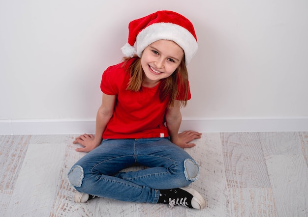 Mała dziewczynka w santa hat na podłodze