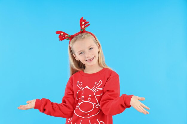 Mała dziewczynka w świątecznych ubraniach na niebieskim tle