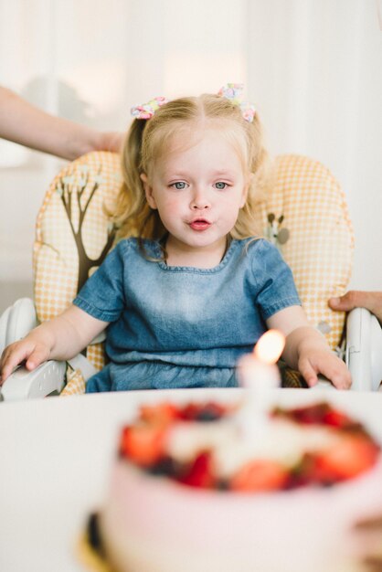 Mała dziewczynka w swoje urodziny przyjmuje gratulacje i zjada ciasto