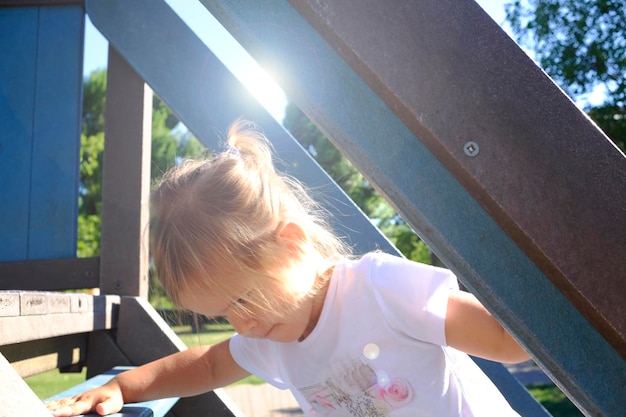 Mała dziewczynka wspina się po schodach na placu zabaw Koncepcja dzieciństwa Koncepcja wzrostu