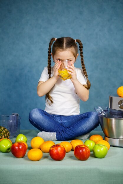 Mała Dziewczynka Wyciska świeży Sok Z Owoców Jabłek I Pomarańczy. Witaminy I Zdrowe Odżywianie Dla Dzieci.