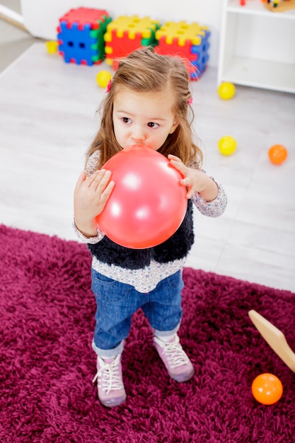 Mała dziewczynka z balonem w pokoju
