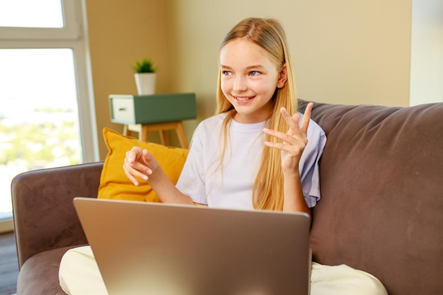 Zdjęcie mała dziewczynka z długimi włosami za pomocą laptopaodrabiania lekcji w domupowrót do koncepcji szkoły