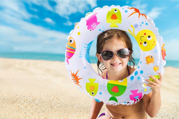 Zdjęcie mała dziewczynka z kółkiem do pływania na plaży