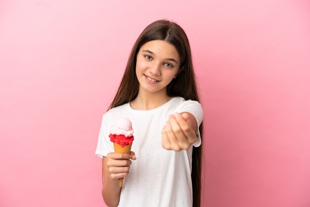 Mała dziewczynka z lodami kornetowymi na na białym tle różowym gestem zarabiania pieniędzy